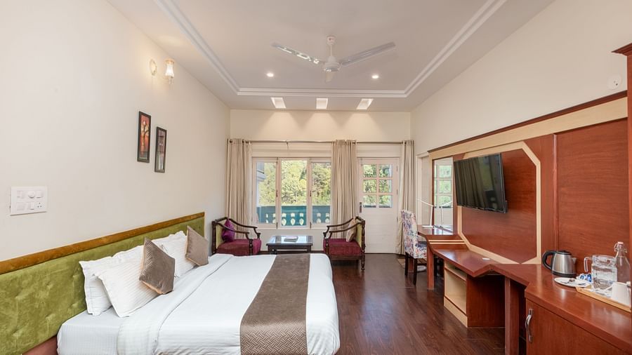 Image of a room at DLS Tehri Club Resort offering a relaxing space with a comfortable bed and seating.